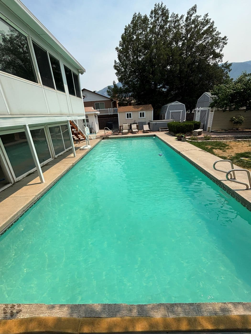 The same pool with clear blue water and the mountains behind