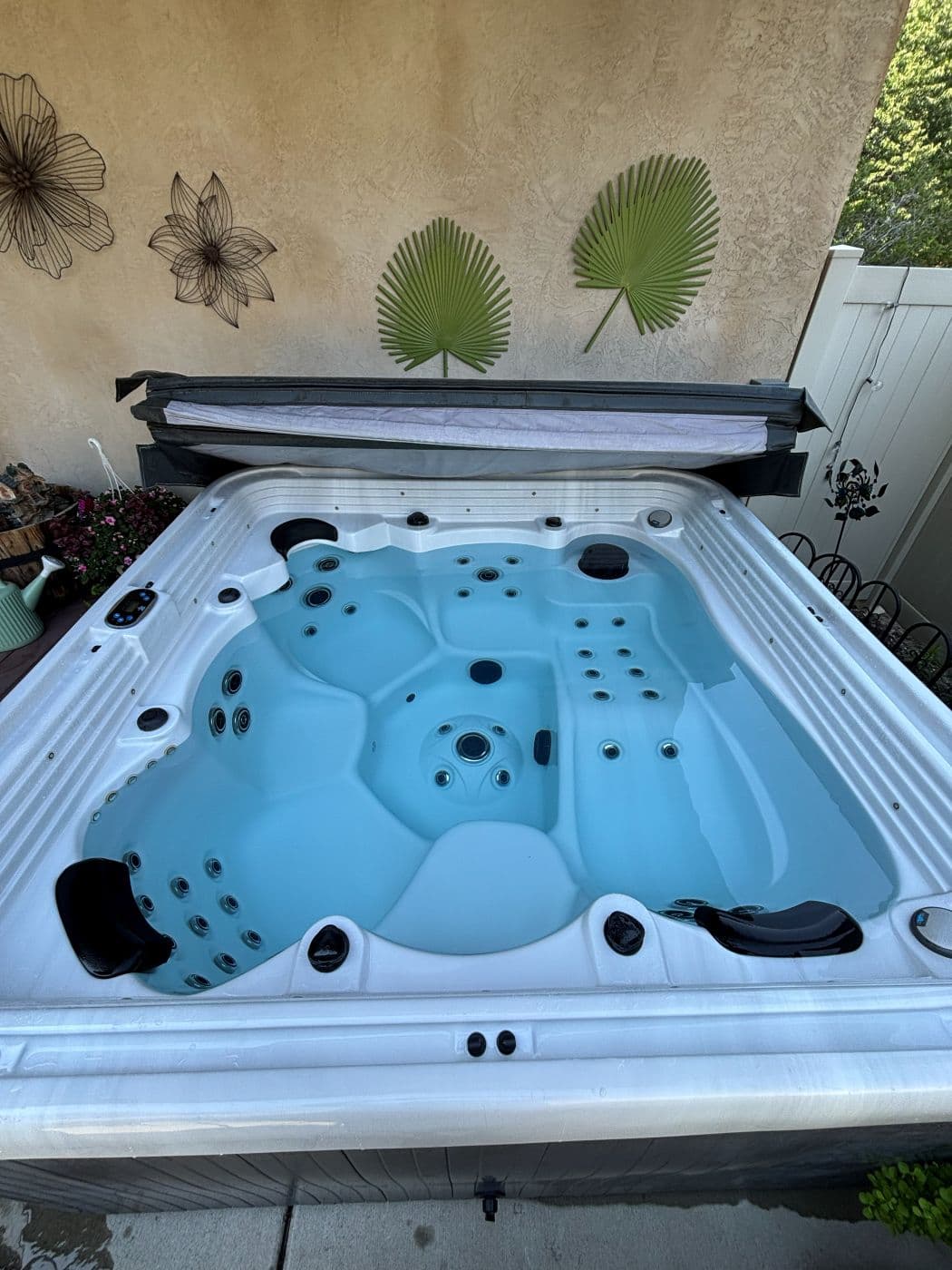 Overhead view of a hot tub with clear blue water and the cover open