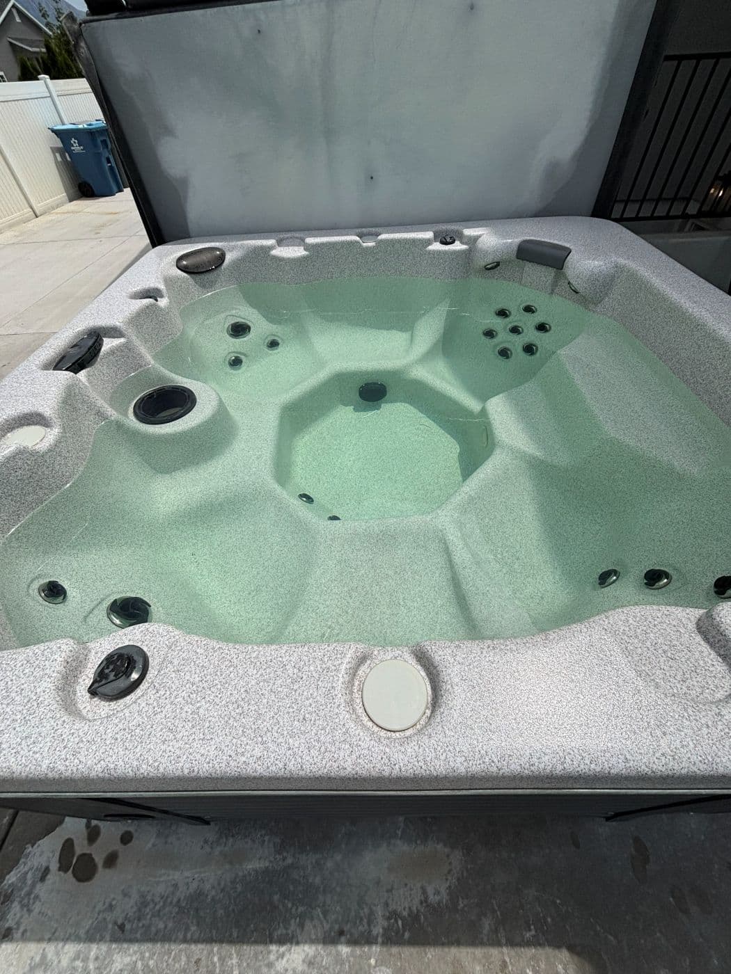 Hot tub with green murky water before a drain, clean and refill